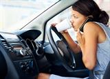 Businesswoman multitasking while driving, drinking coffee and talking on the phone-distractions